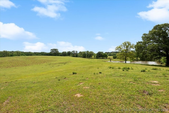 view of yard with a water view and a rural view