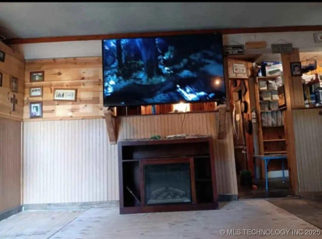 unfurnished living room featuring wooden walls and a fireplace