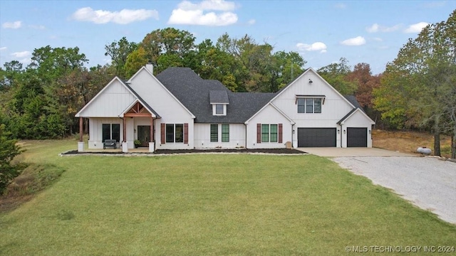 modern inspired farmhouse with a garage and a front lawn