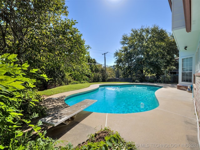 view of pool featuring a diving board and a patio area