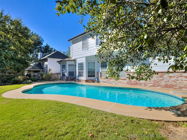 view of swimming pool featuring a yard