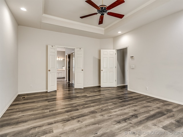 unfurnished bedroom featuring dark hardwood / wood-style flooring, a raised ceiling, ceiling fan, and crown molding