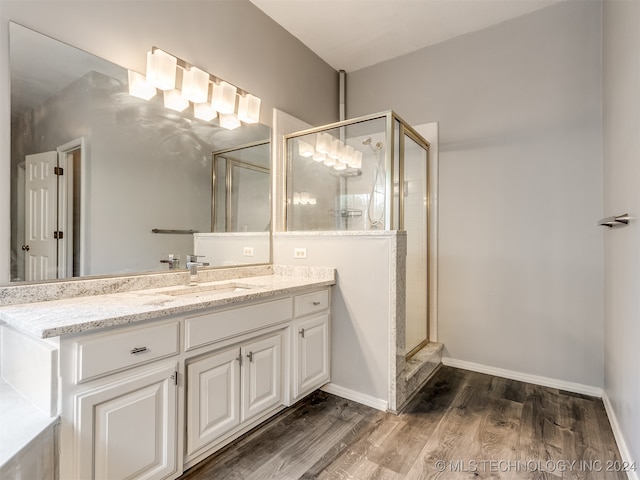 bathroom with vanity, hardwood / wood-style flooring, and a shower with shower door