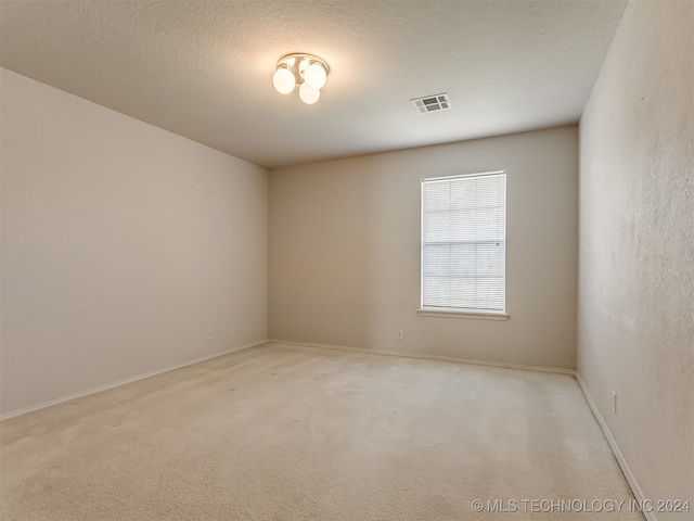 carpeted spare room featuring a textured ceiling