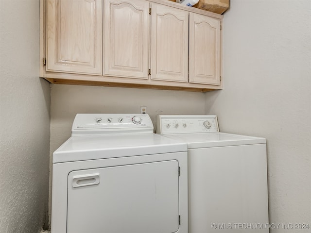 washroom featuring washer and clothes dryer and cabinets