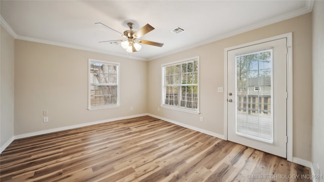 interior space featuring ornamental molding, wood-type flooring, plenty of natural light, and ceiling fan