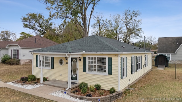 view of front of property featuring a front yard and a storage unit