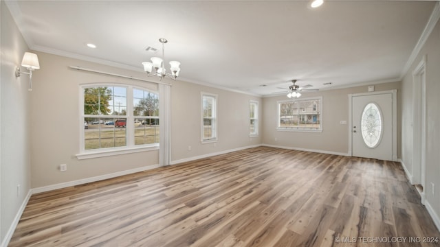 unfurnished living room featuring ornamental molding, light wood-type flooring, and ceiling fan with notable chandelier