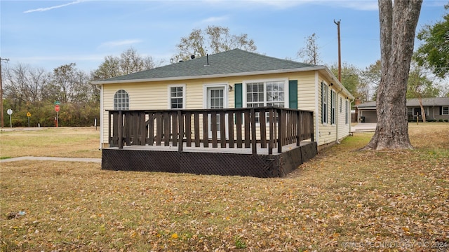 rear view of property featuring a yard and a wooden deck