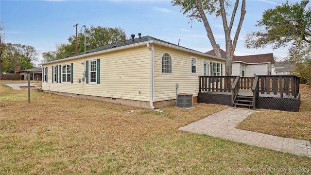 view of front of house with central air condition unit, a front yard, and a deck