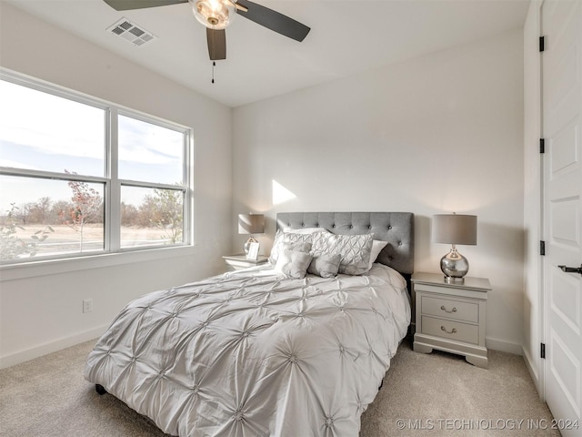 bedroom featuring baseboards, ceiling fan, visible vents, and light colored carpet