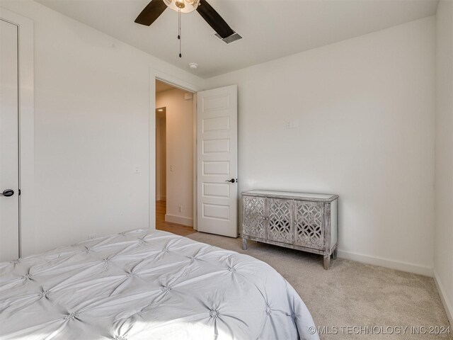 bedroom with ceiling fan and light carpet