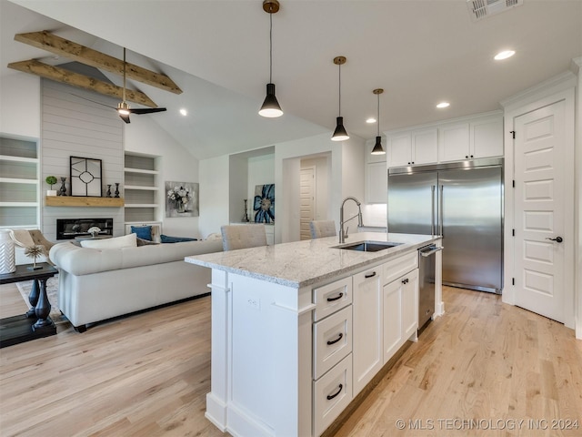 kitchen featuring a sink, visible vents, white cabinets, light wood-type flooring, and stainless steel built in fridge