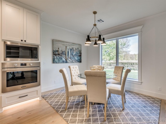 dining space with ornamental molding, wood finished floors, visible vents, and baseboards