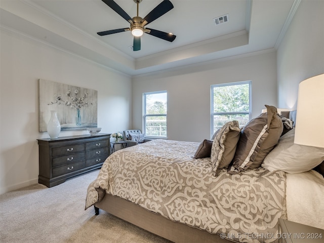 bedroom with ornamental molding, a raised ceiling, light colored carpet, and ceiling fan