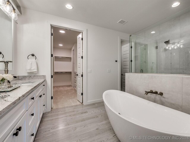 bathroom with vanity, hardwood / wood-style flooring, and separate shower and tub