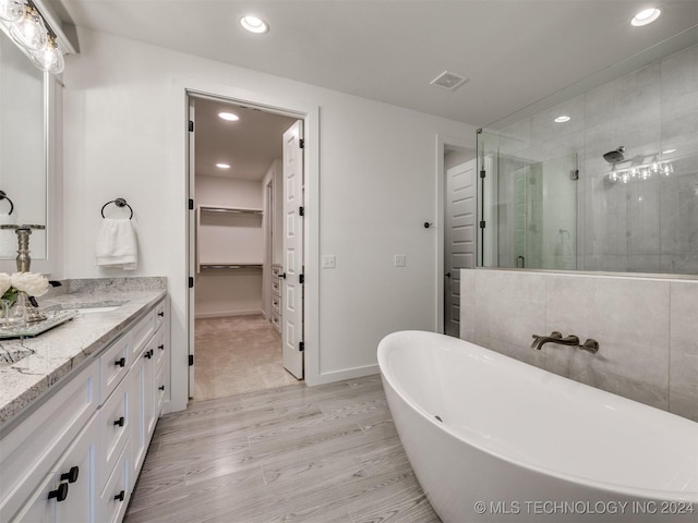 full bathroom featuring recessed lighting, wood finished floors, visible vents, a spacious closet, and a stall shower