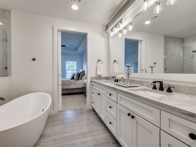 bathroom with vanity, hardwood / wood-style flooring, and shower with separate bathtub