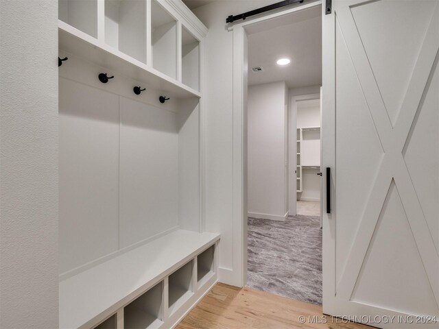 mudroom featuring a barn door and light wood-type flooring