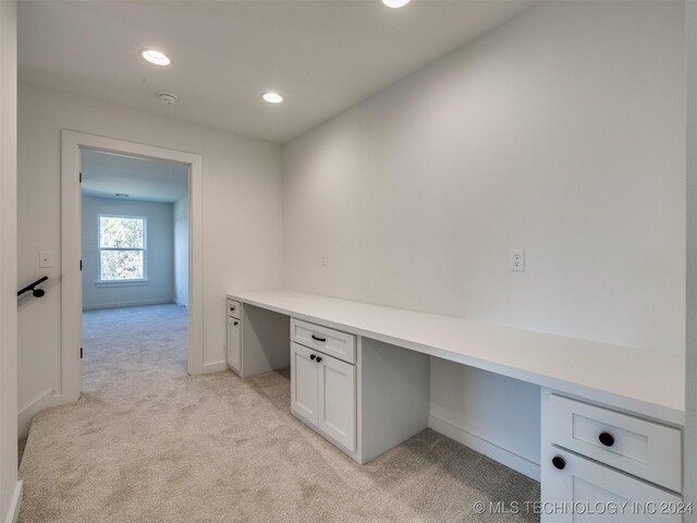 unfurnished office with light colored carpet and built in desk