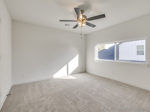 carpeted spare room featuring ceiling fan