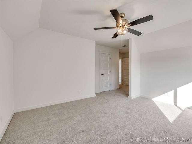 unfurnished bedroom featuring light carpet, visible vents, baseboards, a ceiling fan, and vaulted ceiling