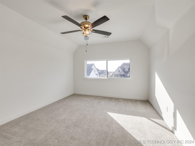 interior space with visible vents, baseboards, light colored carpet, lofted ceiling, and ceiling fan