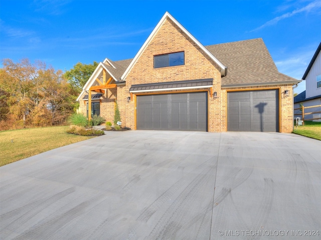 view of front of house featuring a shingled roof, concrete driveway, brick siding, and a front lawn