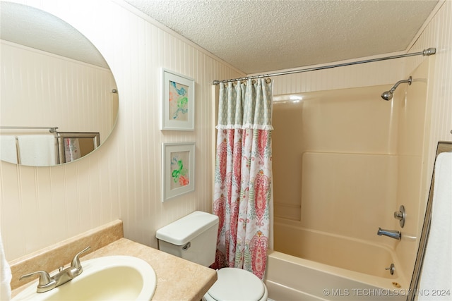 full bathroom with toilet, wooden walls, vanity, a textured ceiling, and shower / bathtub combination with curtain