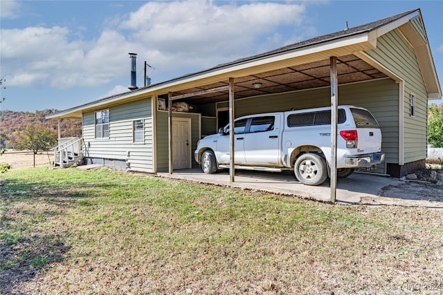 view of parking with a lawn and a carport