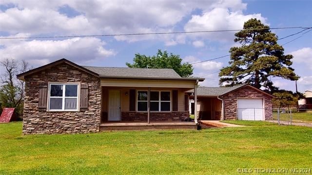 view of front of property featuring a front yard, a porch, and a garage