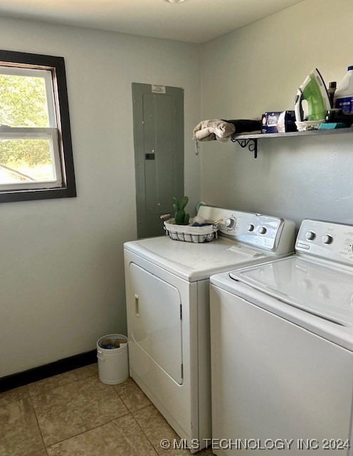 washroom featuring light tile patterned floors, electric panel, and washer and clothes dryer