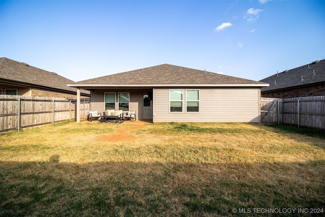 rear view of property featuring a lawn