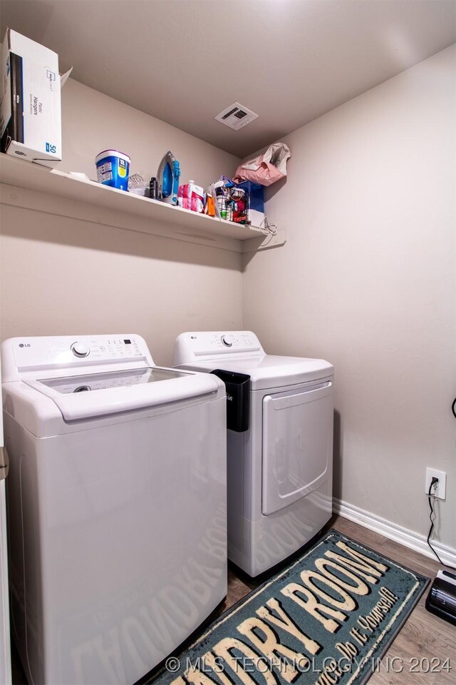 laundry room featuring washer and clothes dryer and hardwood / wood-style floors