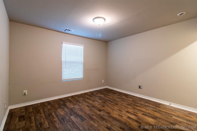 unfurnished room with dark wood-type flooring