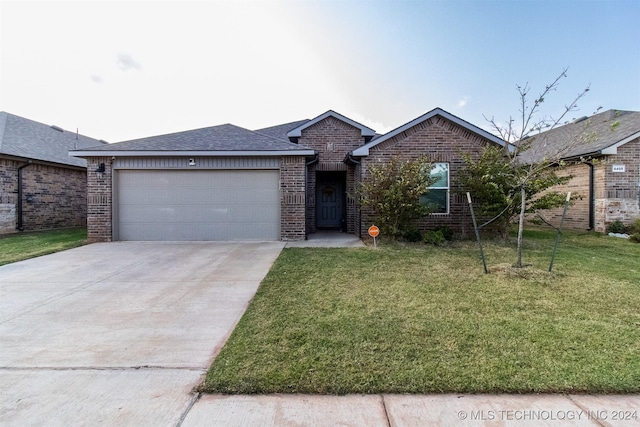 single story home featuring a garage and a front lawn