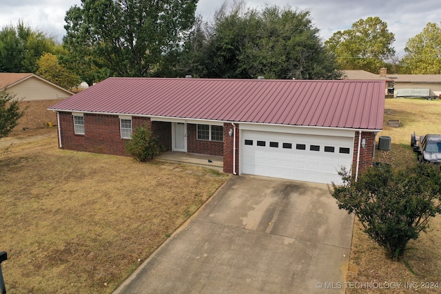 ranch-style house featuring central air condition unit, covered porch, a front yard, and a garage