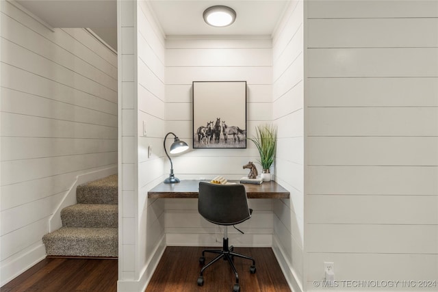 home office featuring dark wood-type flooring, crown molding, built in desk, and wooden walls