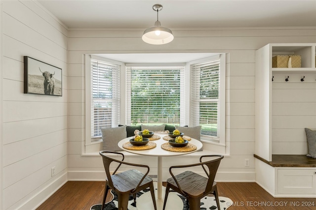 dining room with breakfast area, dark hardwood / wood-style floors, and wooden walls