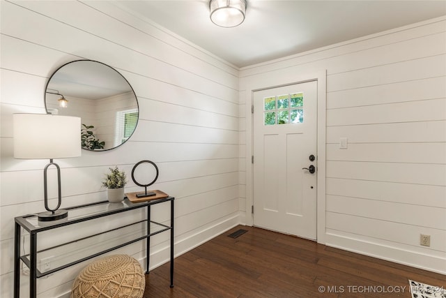 entryway featuring dark wood-type flooring and wooden walls