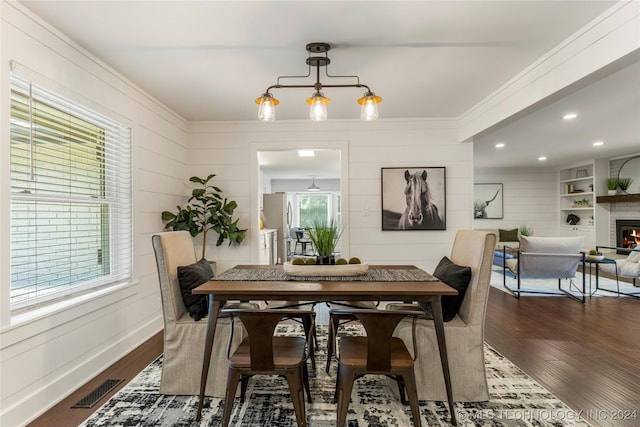 dining space featuring dark hardwood / wood-style flooring, built in features, and plenty of natural light