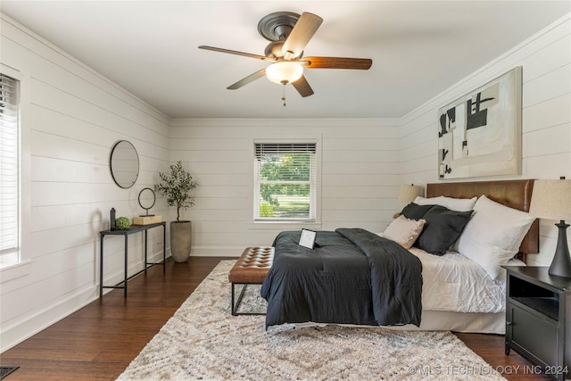 bedroom featuring dark wood-type flooring, ceiling fan, and wooden walls