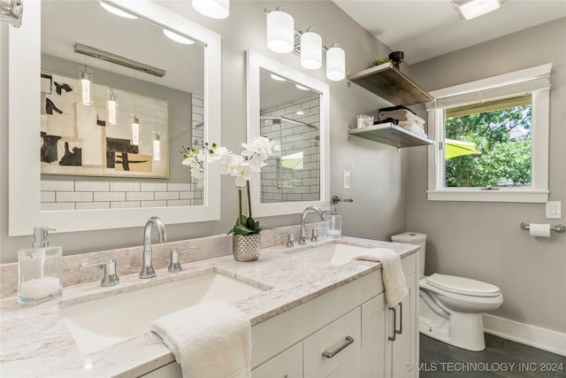 bathroom featuring toilet, vanity, a shower, and tile patterned floors