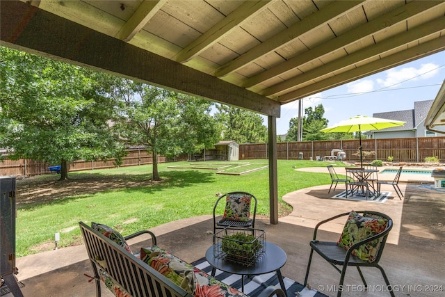 view of patio / terrace featuring a fenced in pool and a storage unit