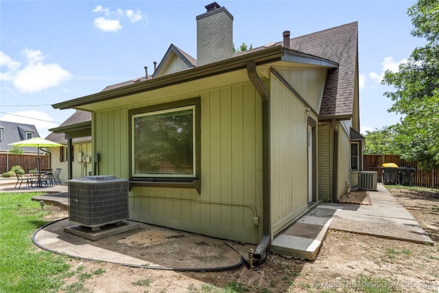 view of side of home with a patio area and central AC