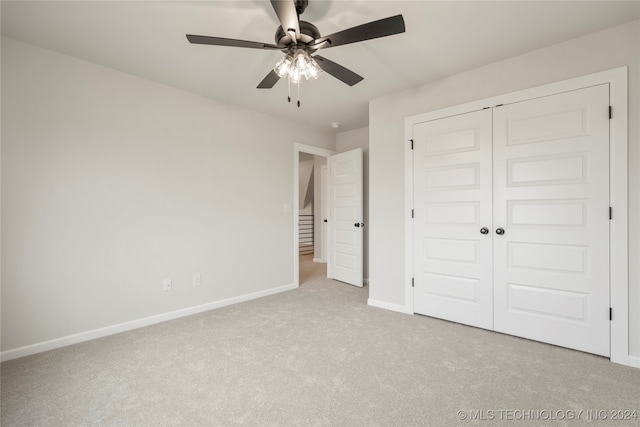 unfurnished bedroom with ceiling fan, a closet, and light colored carpet