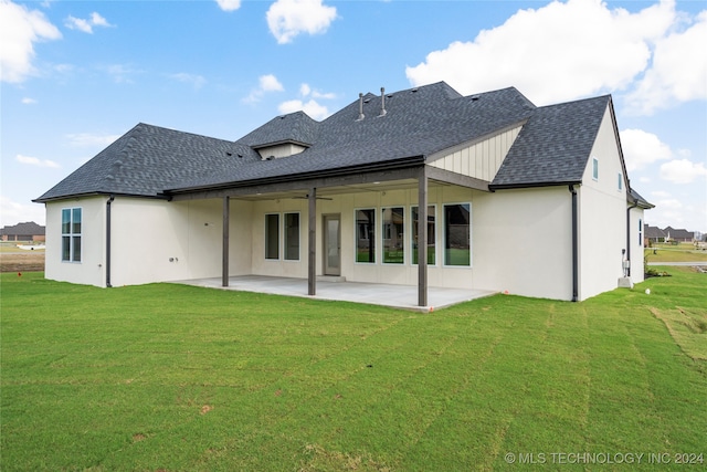 back of property with a lawn and a patio area