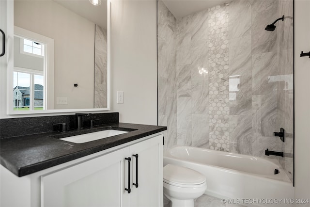 full bathroom featuring toilet, vanity, and tiled shower / bath