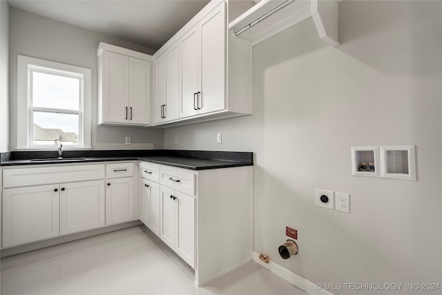 clothes washing area featuring electric dryer hookup, cabinets, sink, washer hookup, and light tile patterned flooring