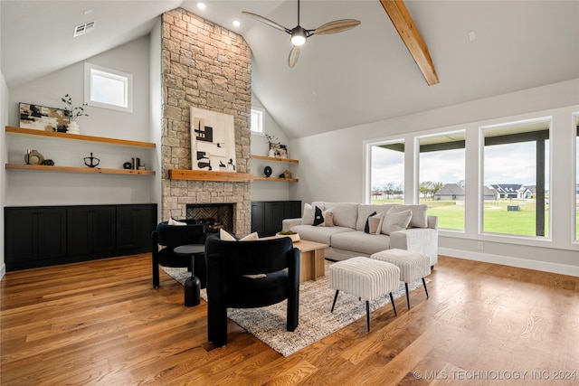 living room with ceiling fan, beam ceiling, high vaulted ceiling, a fireplace, and light wood-type flooring